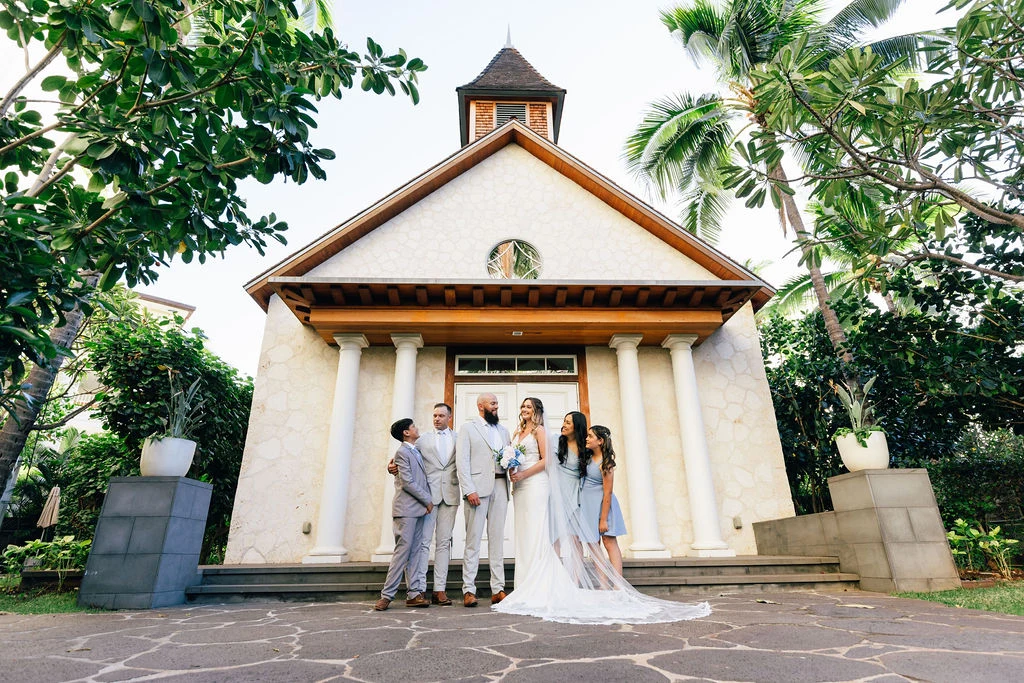 Wedding party posing in front of a chapel