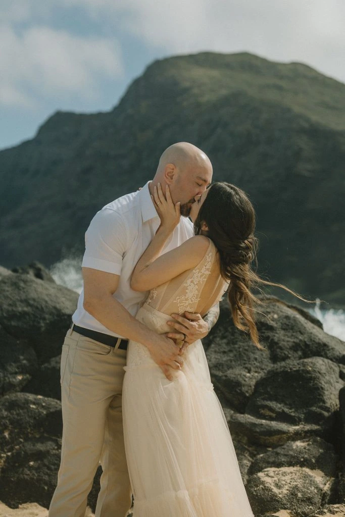 Couple kissing by the rocky shore