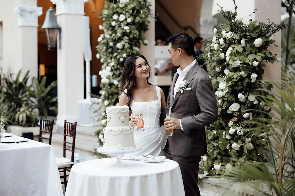 Couple standing by their wedding cake