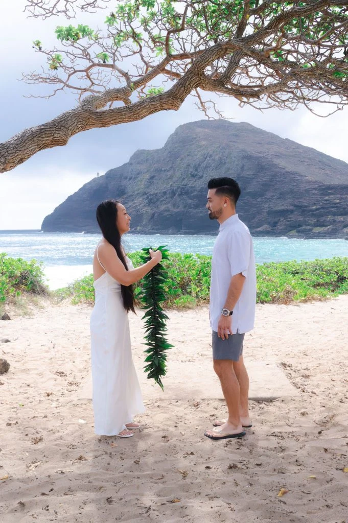 Couple exchanging leis on the beach