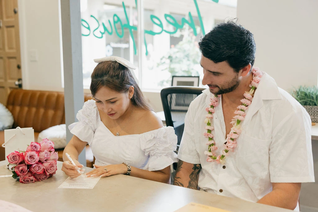 In-office private marriage license agent in Honolulu reviewing identification documents for a couple.